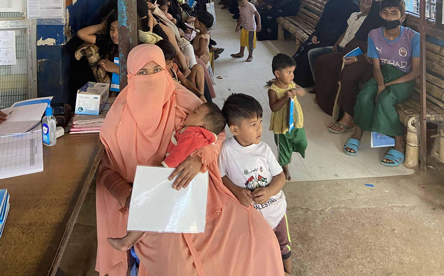 Dans une salle d’attente, des femmes patientent avec leurs enfants.