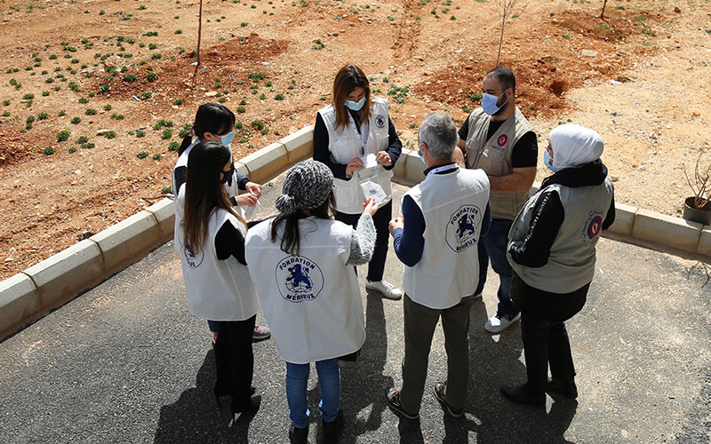 Groupe de personnes en gilet blanc rassemblées à l’extérieur du Centre de santé de Douris au Liban
